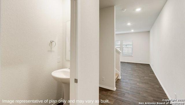 bathroom with baseboards, wood finished floors, and recessed lighting