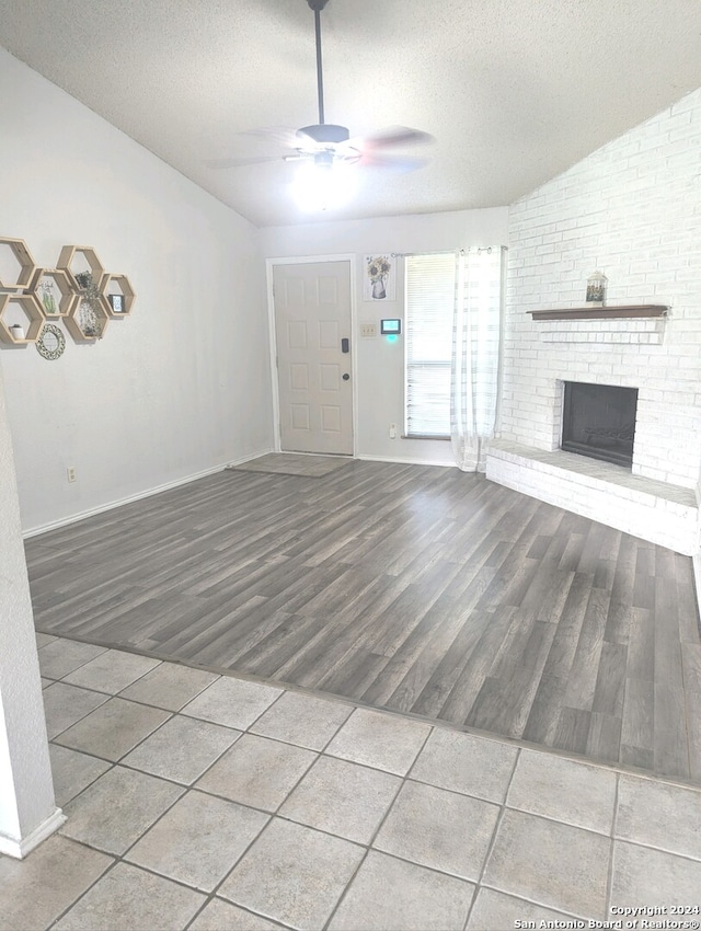 unfurnished living room featuring a textured ceiling, wood-type flooring, and a fireplace