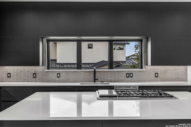 kitchen featuring backsplash, stainless steel gas cooktop, and sink