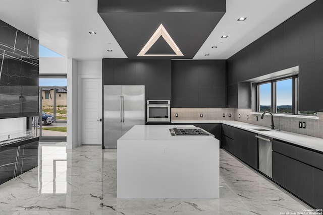 kitchen featuring appliances with stainless steel finishes, backsplash, a large island, and sink