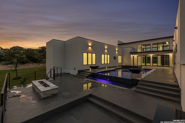 exterior space featuring a jacuzzi, an outdoor fire pit, and a patio area