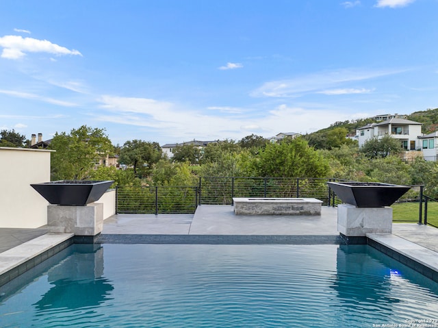 view of pool with a hot tub and a patio area