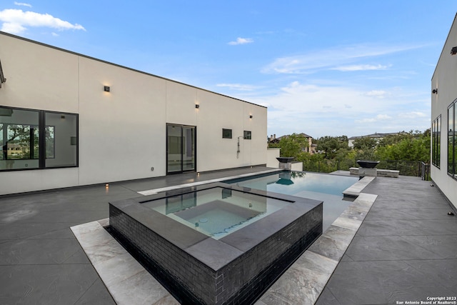 view of swimming pool featuring an in ground hot tub and a patio