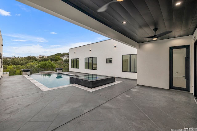 view of swimming pool featuring ceiling fan, an in ground hot tub, and a patio