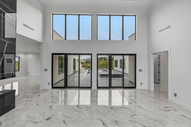 unfurnished living room with a healthy amount of sunlight and a high ceiling