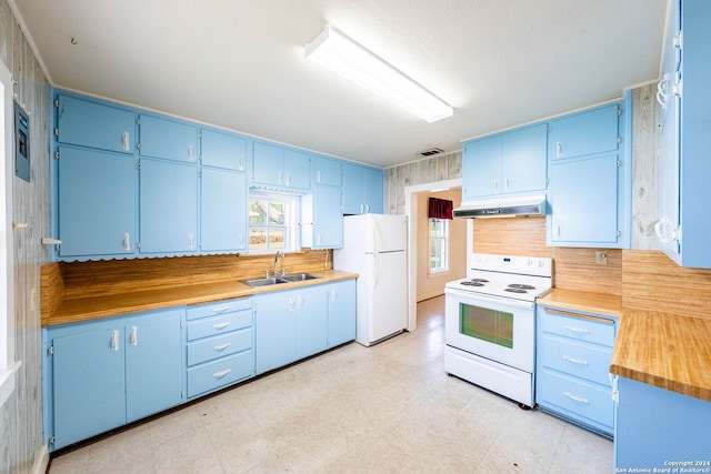 kitchen with white appliances, sink, blue cabinetry, and light tile floors