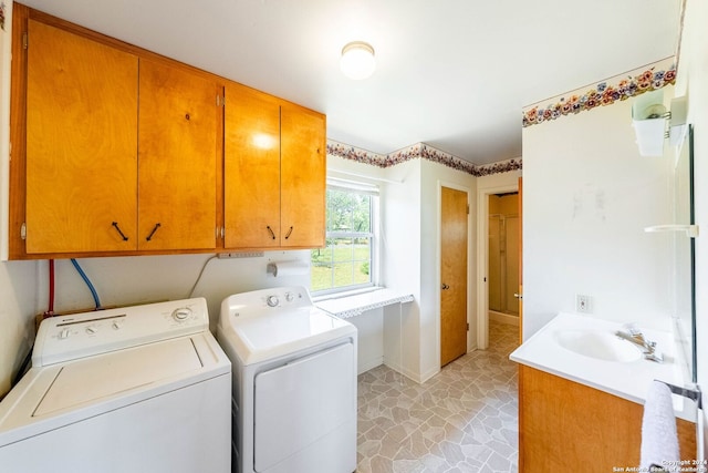 washroom with cabinets, sink, washer and clothes dryer, and light tile floors