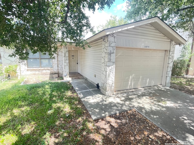 view of front of home featuring a garage, concrete driveway, and stone siding