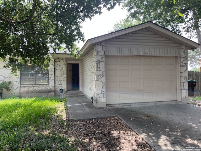 view of front facade featuring a garage, stone siding, and concrete driveway