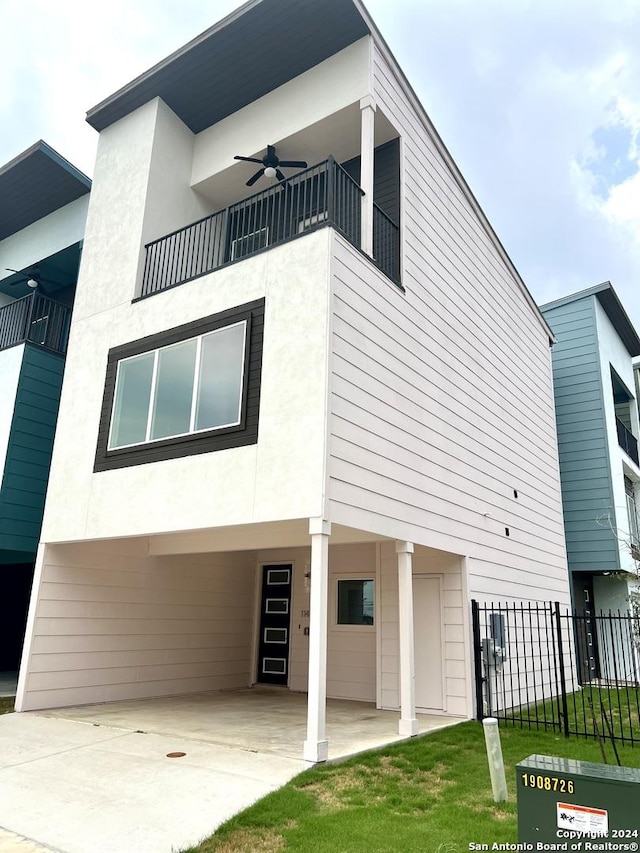 exterior space featuring ceiling fan, a balcony, and a front lawn