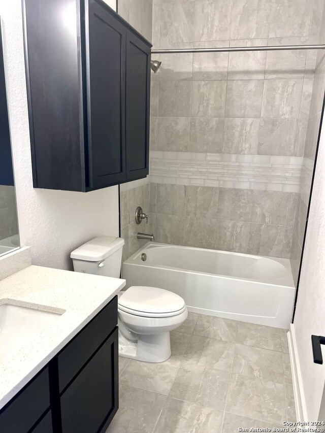 full bathroom with vanity, tiled shower / bath combo, and toilet