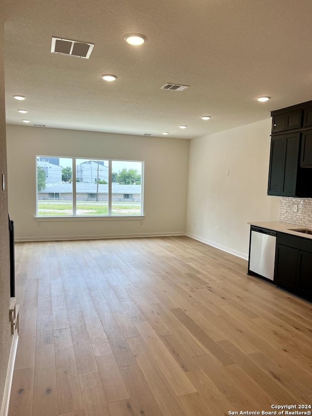 unfurnished living room with light hardwood / wood-style floors and sink