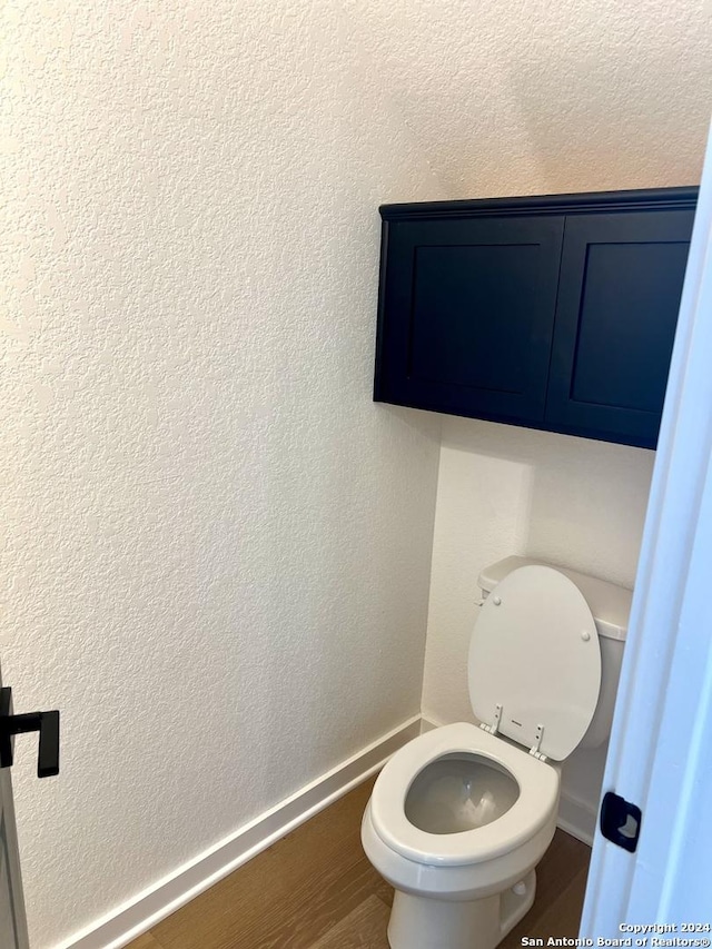 bathroom with hardwood / wood-style floors and toilet