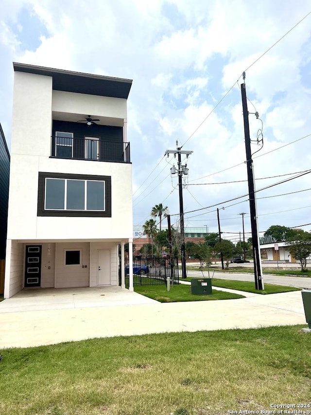 rear view of house featuring a lawn and a balcony