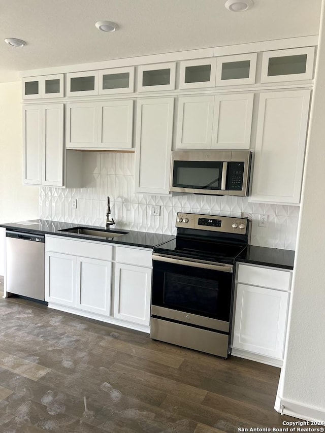 kitchen with tasteful backsplash, white cabinetry, sink, and appliances with stainless steel finishes