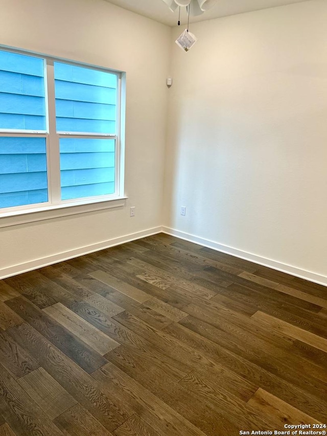 unfurnished room featuring ceiling fan and dark wood-type flooring