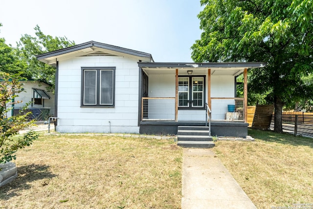 bungalow-style house with covered porch, fence, and a front yard