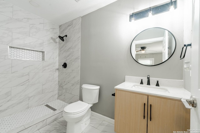 full bathroom with a stall shower, baseboards, toilet, marble finish floor, and vanity