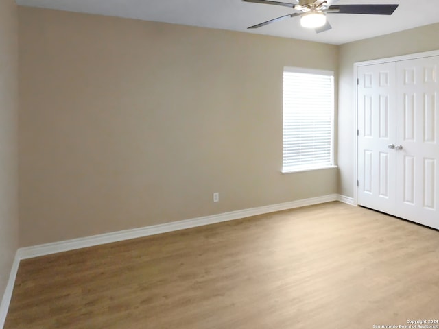 unfurnished bedroom featuring ceiling fan, a closet, and light hardwood / wood-style floors