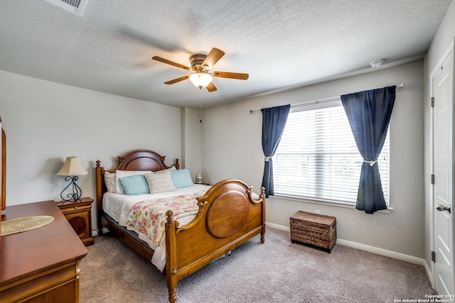 carpeted bedroom with a textured ceiling and ceiling fan