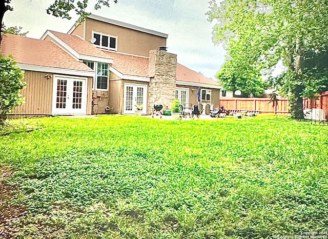 back of property featuring a lawn, a patio area, and french doors