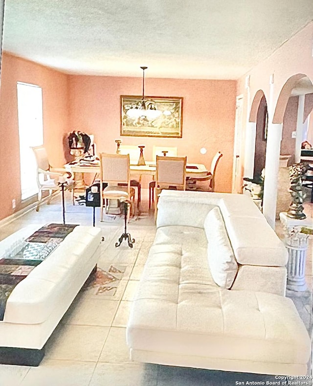 living room with a textured ceiling and light tile patterned flooring