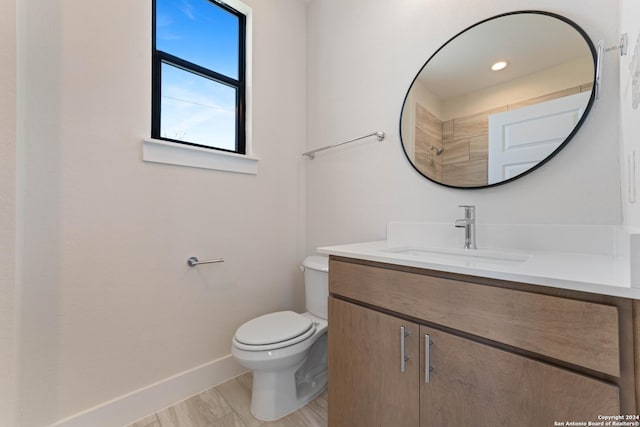 bathroom with hardwood / wood-style floors, vanity, and toilet