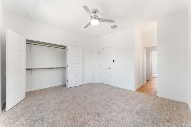 unfurnished bedroom featuring ceiling fan, a closet, and light colored carpet