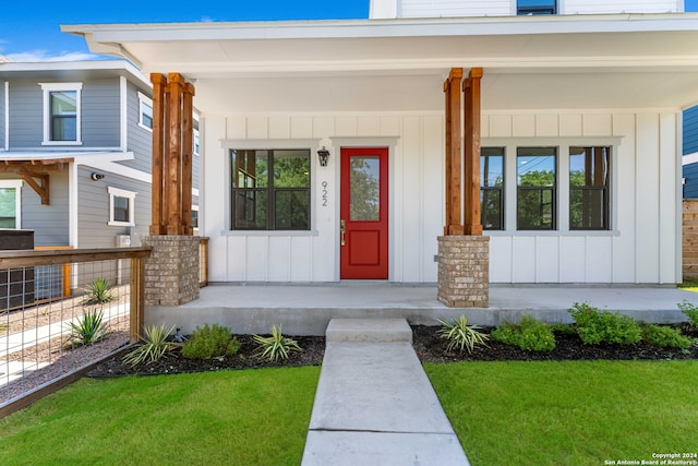 property entrance featuring a yard and covered porch