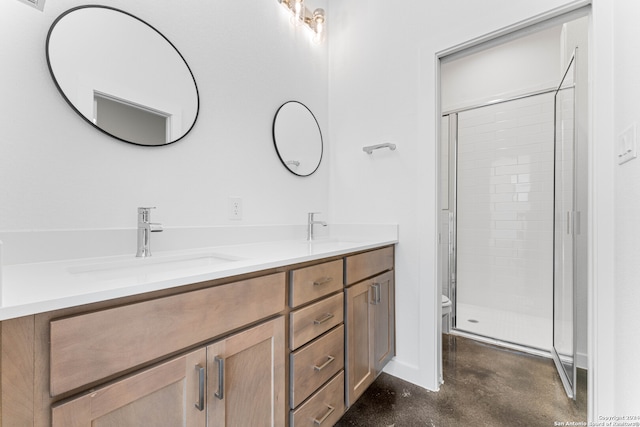 bathroom with a shower with shower door, oversized vanity, double sink, and toilet