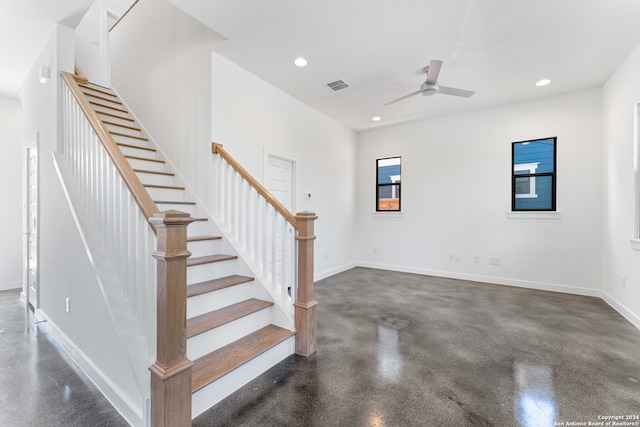 stairs featuring ceiling fan