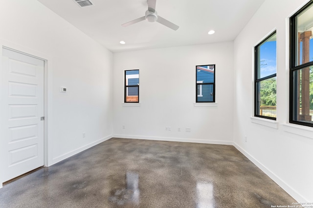 unfurnished room with ceiling fan and concrete flooring