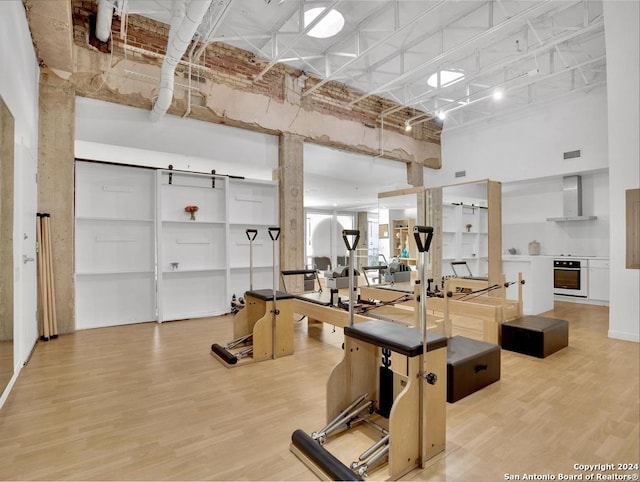 exercise room featuring hardwood / wood-style flooring and a high ceiling