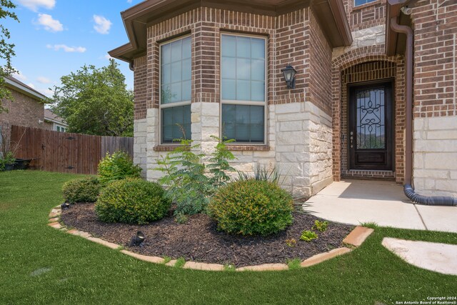 entrance to property featuring a lawn