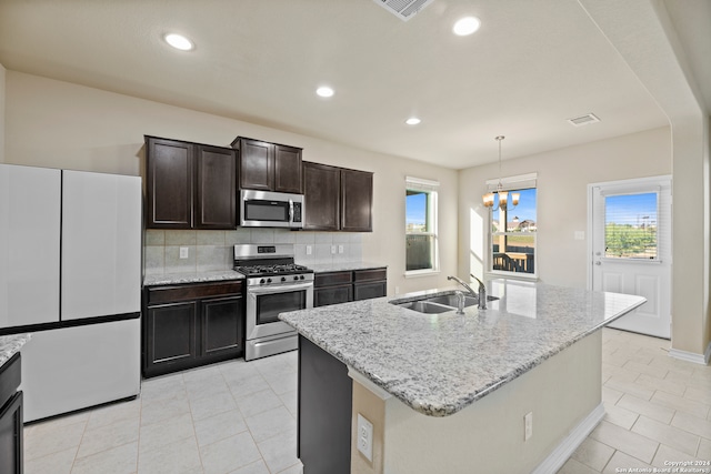 kitchen with sink, a healthy amount of sunlight, a center island with sink, and appliances with stainless steel finishes