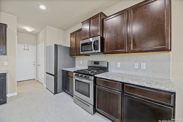 kitchen with dark brown cabinets, appliances with stainless steel finishes, and tasteful backsplash