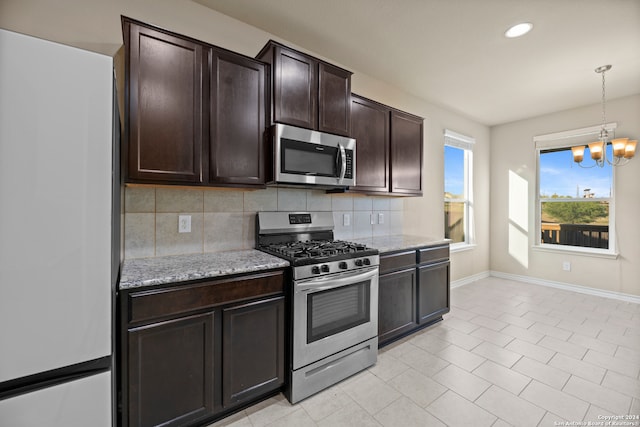 kitchen featuring tasteful backsplash, dark brown cabinetry, stainless steel appliances, and a chandelier