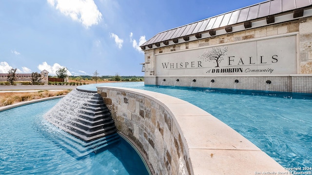 view of swimming pool with pool water feature