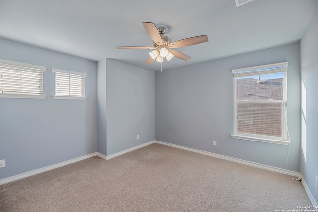 empty room featuring ceiling fan and light carpet