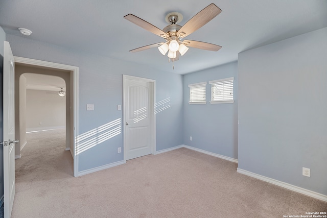 unfurnished bedroom featuring light carpet, a closet, and ceiling fan