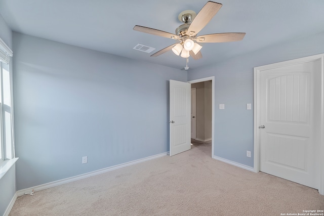 spare room featuring ceiling fan and light carpet