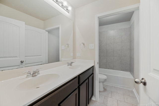 full bathroom featuring tile patterned floors, tiled shower / bath, vanity, and toilet