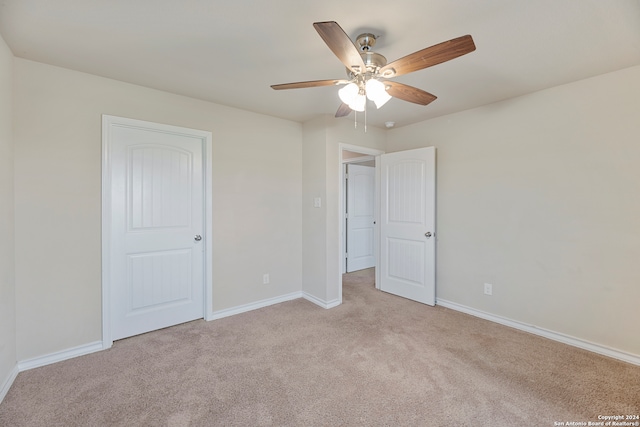 unfurnished bedroom featuring light carpet and ceiling fan