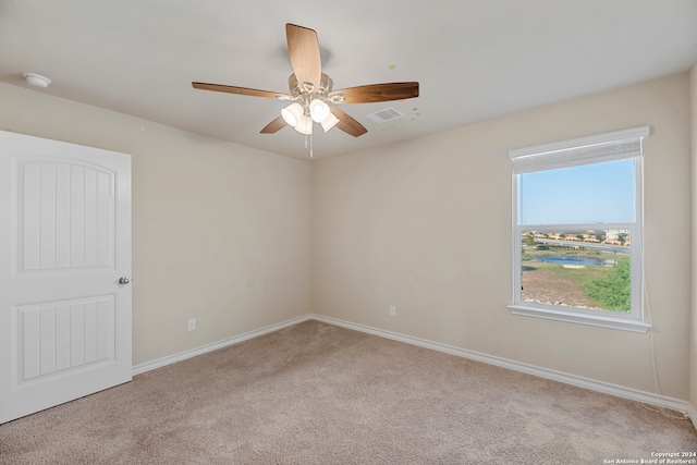 carpeted spare room featuring ceiling fan