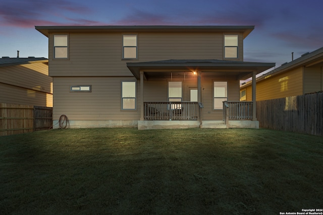 back house at dusk with a yard