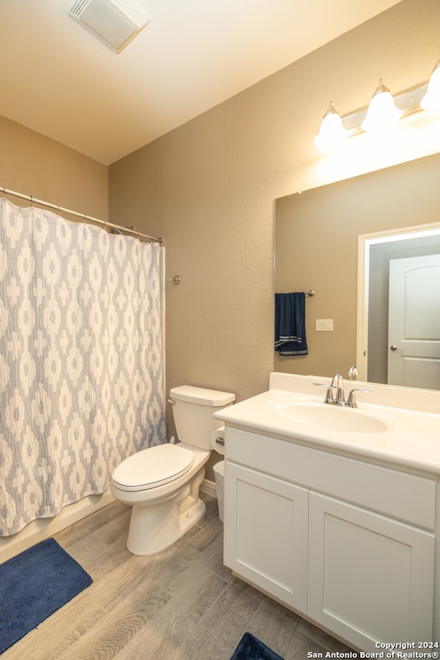 bathroom with hardwood / wood-style floors, vanity, and toilet