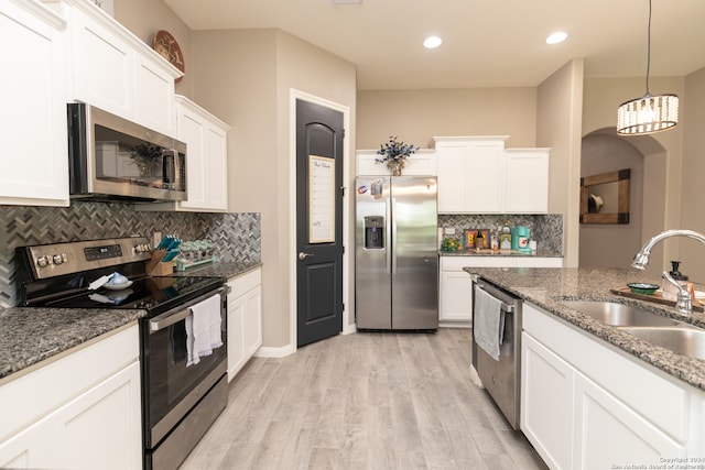 kitchen featuring tasteful backsplash, light hardwood / wood-style flooring, stone countertops, and stainless steel appliances