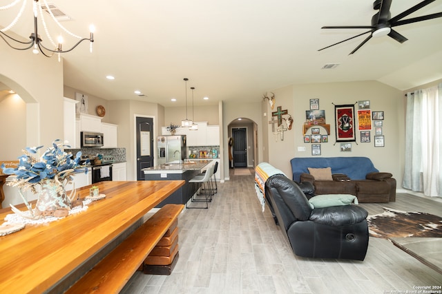 dining room with ceiling fan with notable chandelier, light hardwood / wood-style floors, and sink