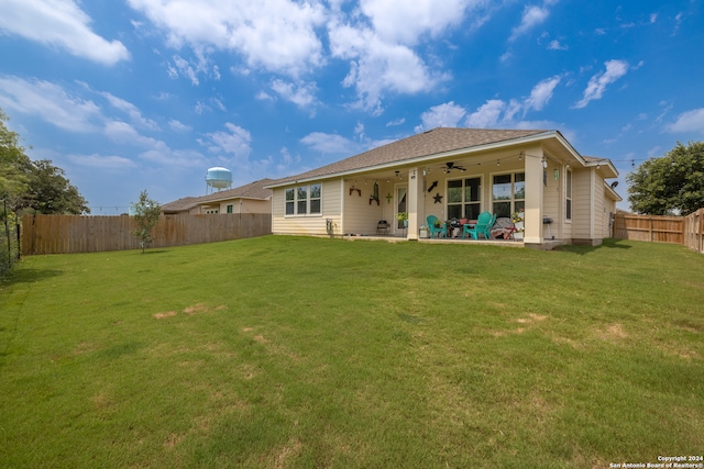 back of house with ceiling fan, a lawn, and a patio