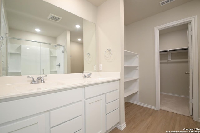 bathroom featuring walk in shower, vanity, and hardwood / wood-style flooring